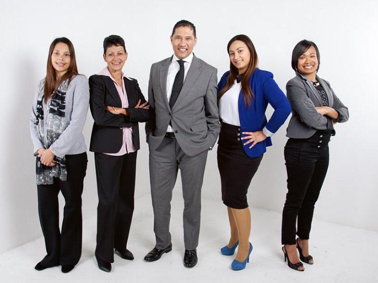 Five individuals in professional attire pose for group shot